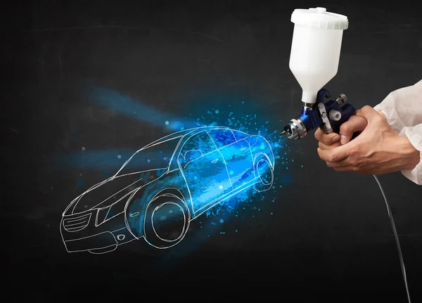 Worker with airbrush gun painting hand drawn car lines — Stock Photo, Image