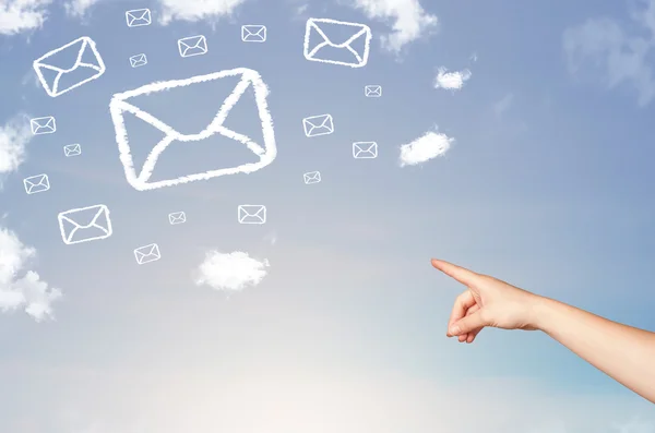 Mano apuntando a las nubes símbolo de correo en el cielo azul —  Fotos de Stock