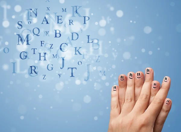 Happy smiley fingers looking at mixture of bokeh letters — Stock Photo, Image