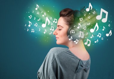 Kulaklıklı genç bir kadın müzik dinliyor.