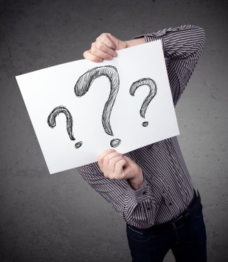 onun önünde soru işareti olan bir kağıt tutan işadamı