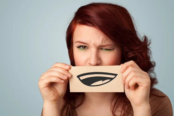 Pretty young girl holding white card with smile drawing — Stock Photo, Image