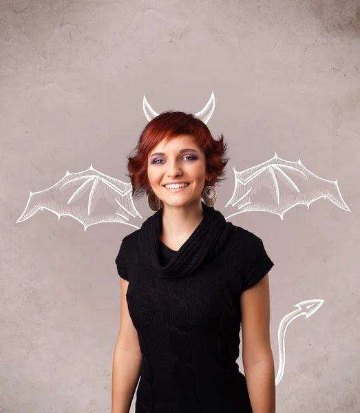 Молода дівчина з диявольськими рогами та малюнком крил — стокове фото