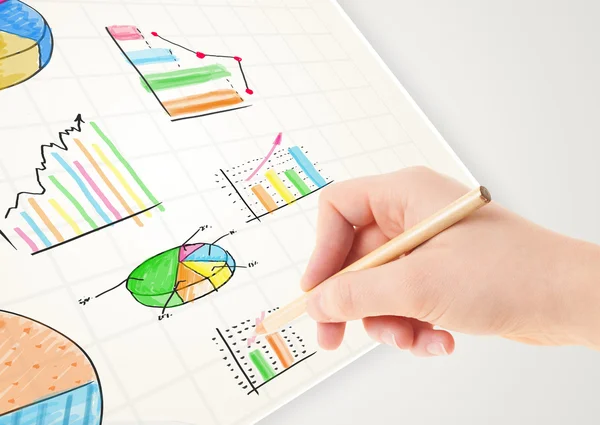 Business person drawing colorful graphs and icons on paper — Stock Photo, Image