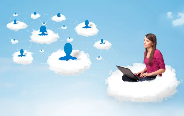 Young woman sitting in cloud with laptop — Stock Photo, Image