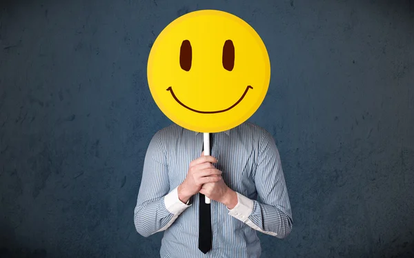 stock image Businessman holding a smiley face emoticon