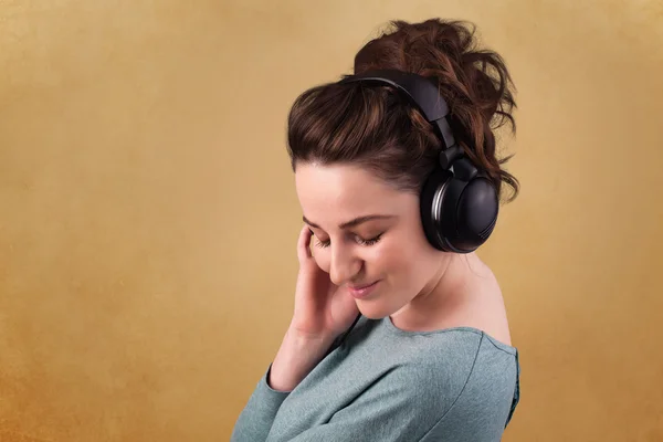 Mujer joven con auriculares escuchando música con espacio para copiar — Foto de Stock