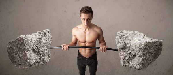 Hombre muscular levantando grandes pesos de piedra de roca —  Fotos de Stock