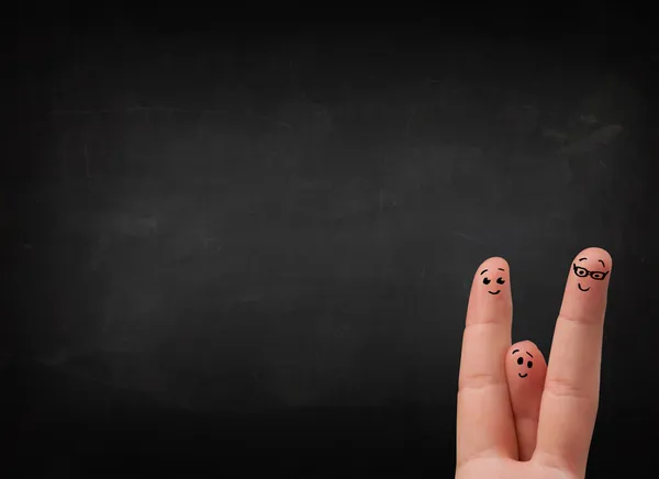 Happy smiley fingers looking at empty black chalboard — Stock Photo, Image