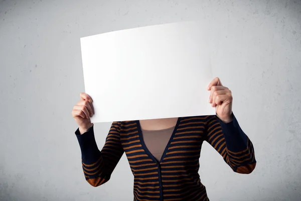 Woman holding in front of her head a paper with copy space Royalty Free Stock Photos