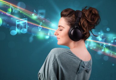 Kulaklıkla müzik dinleyen genç bir kadın.