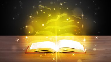 Altından parlak uçan kağıt sayfaları olan açık bir kitap