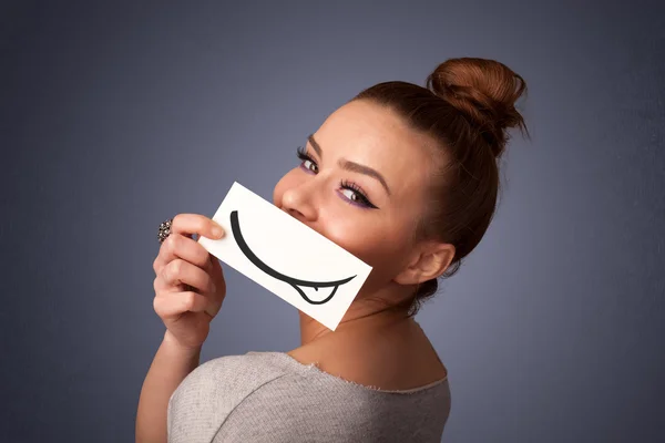 Jolie jeune fille tenant carte blanche avec dessin sourire — Photo