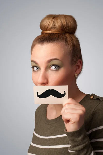 Happy cute girl holding paper with mustache drawing — Stock Photo, Image