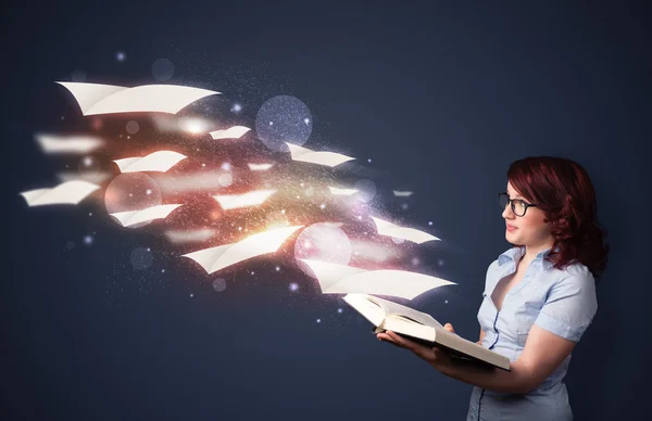 Young lady reading a book with flying sheets coming out of the b — Stockfoto