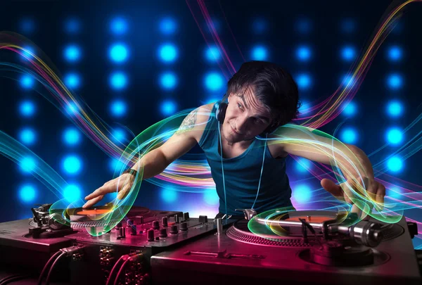 Jovem Dj misturando registros com luzes coloridas — Fotografia de Stock