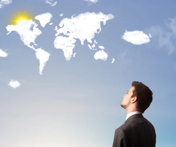 Businessman looking at world clouds and sun on blue sky — Stock Photo, Image