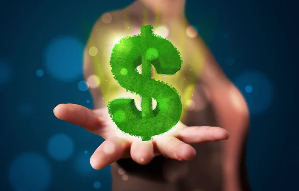 Young woman presenting green glowing dollar sign — Stock Photo, Image