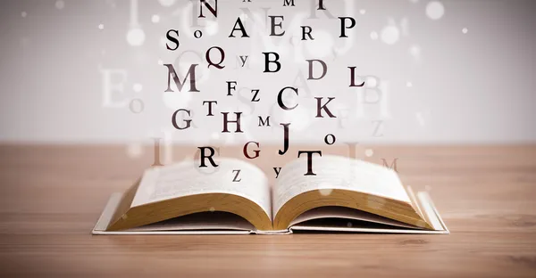 Livre ouvert avec lettres volantes — Photo