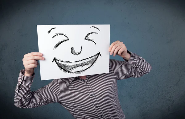 Empresário segurando um papel com rosto sorridente na frente de sua hea — Fotografia de Stock