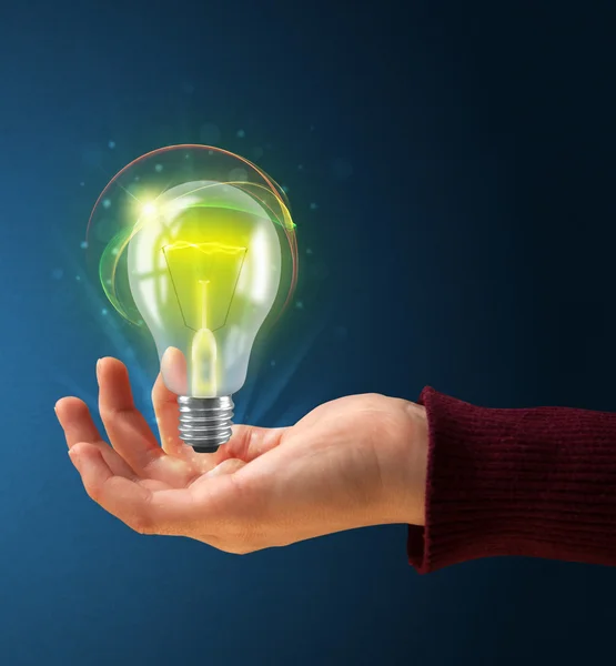 Glowing lightbulb in the hand of a woman — Stock Photo, Image