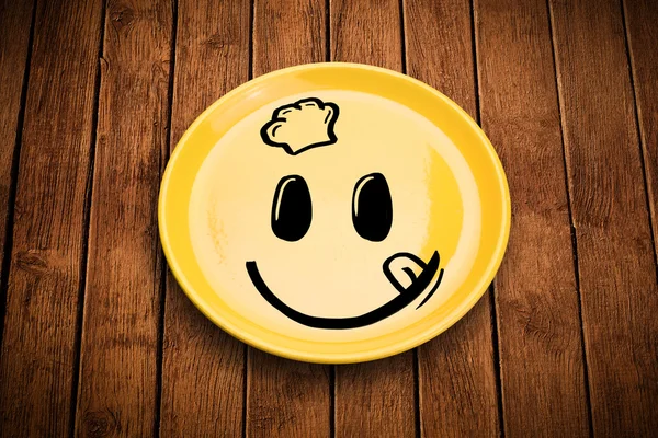 ハッピースマイリー漫画の顔上のカラフルな皿 — ストック写真
