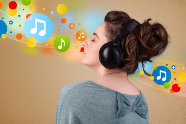 Kulaklıkla müzik dinleyen genç bir kadın.