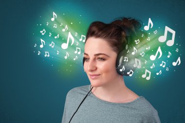 Kulaklıklı genç bir kadın müzik dinliyor.