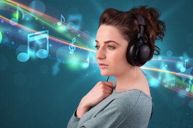 Kulaklıkla müzik dinleyen genç bir kadın.
