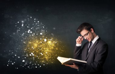 Genç adam sihirli bir kitap okuyor.
