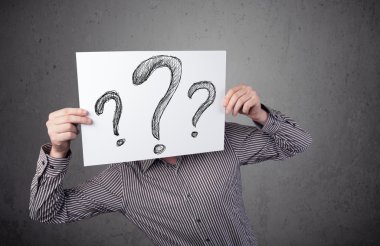 onun önünde soru işareti olan bir kağıt tutan işadamı