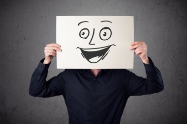 empresario sosteniendo una cartulina con cara sonriente en él en frente