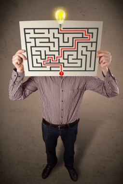 bir labirent ile bir kağıt üzerinde h tutan işadamı