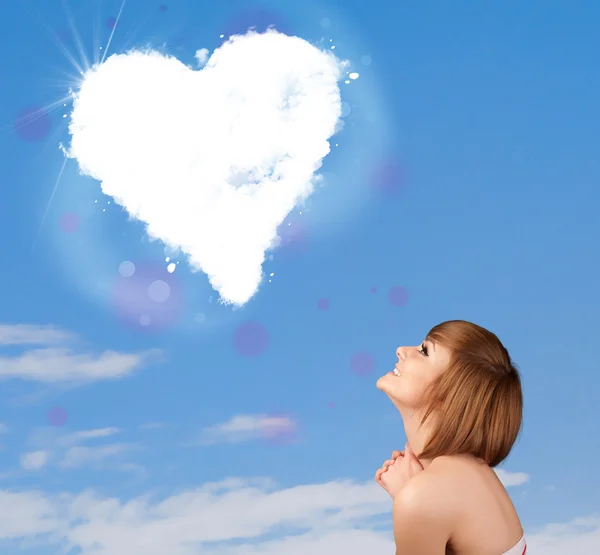 Linda chica mirando a la nube blanca del corazón en el cielo azul —  Fotos de Stock