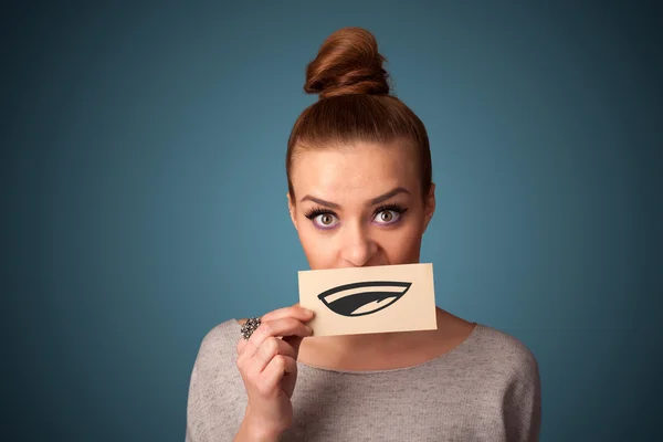 Pretty young girl holding white card with smile drawing — Stock Photo, Image