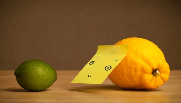 Lemon with post-it note looking at lime — Stock Photo, Image