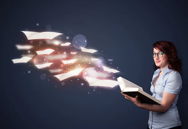 Young lady reading a book with flying sheets coming out of the b — Stockfoto