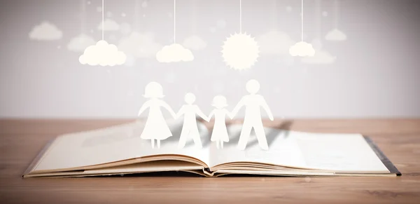 Pappfiguren der Familie auf aufgeschlagenem Buch — Stockfoto