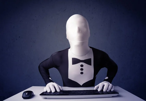 Человек без идентичности работает с клавиатурой на синем фоне — стоковое фото