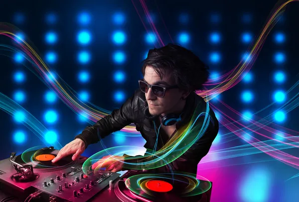 Jovem Dj misturando registros com luzes coloridas — Fotografia de Stock