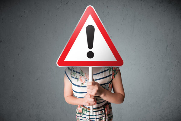 Young woman holding an exclamation road sign