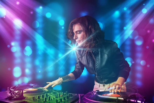 Dj girl mixing music in a club with blue and purple lights — Stock Photo, Image