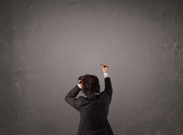 Businessman standing in front of an empty wall — Stock Photo, Image