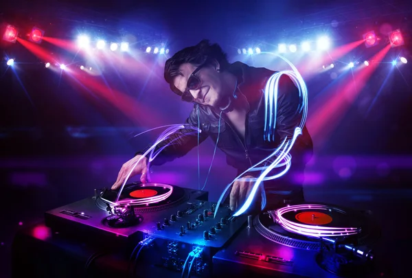 Disc jockey suonare musica con effetti di fascio di luce sul palco — Foto Stock