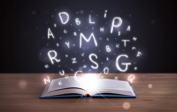 Open book with glowing letters flying out — Stock Photo, Image