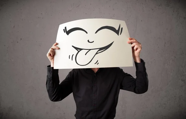 Empresário segurando um papel com cara sorridente engraçado na frente de h — Fotografia de Stock