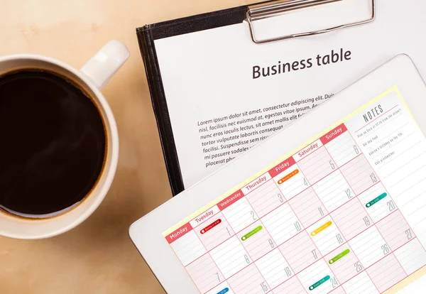 Tablet-PC zeigt Kalender auf dem Bildschirm mit einer Tasse Kaffee auf einem d — Stockfoto