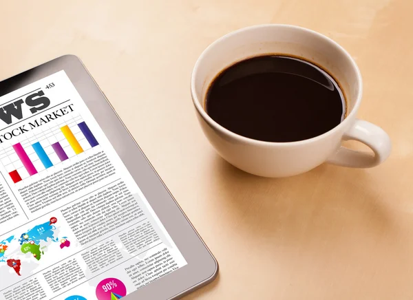 Tablet PC muestra noticias en pantalla con una taza de café en un escritorio — Foto de Stock