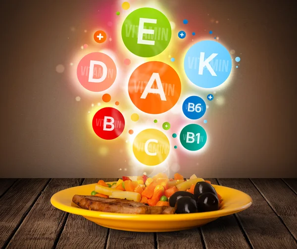 Food plate with delicious meal and healthy vitamin symbols — Stock Photo, Image