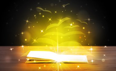 Altından parlak uçan kağıt sayfaları olan açık bir kitap